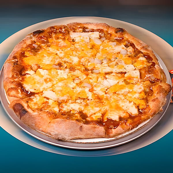A whole Harris Pizza with chicken, cheese, and barbecue sauce on a metal pan.